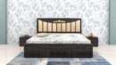 Auric-dark-wood-bed-with-a-cushioned-beige-headboard-and-carved-golden-accent-scaled.webp